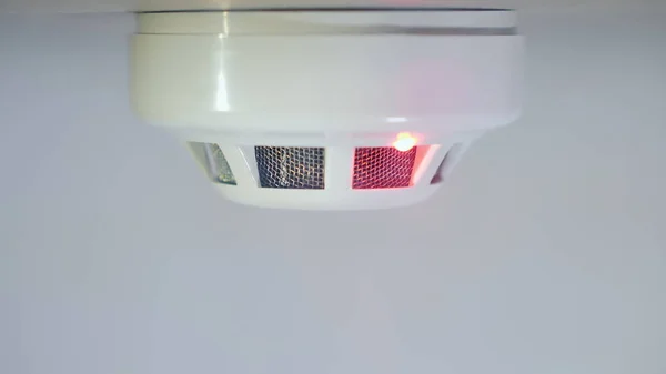 El detector de humo se activa por un chorro de dum, el indicador rojo se ilumina. Fondo blanco — Foto de Stock