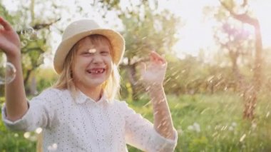 Gülüyor sabun köpüğü ile oynarken mutlu bir çocuk. Slow motion video