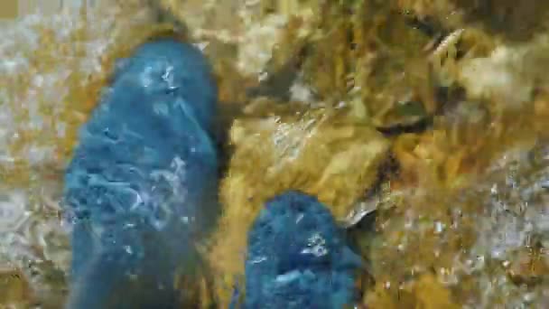 Un uomo in stivali di gomma si trova in acqua in un fiume tempestoso, la vista dall'alto — Video Stock