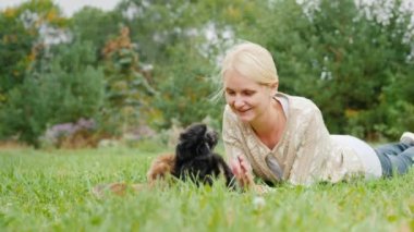 Onun arka bahçesinde çimenlerin üzerine yalan bir iki kukla ile oynayan kadın. 4 k ağır çekim video