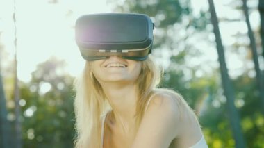 Sarışın bir genç kadın bir kask bir sanal gerçeklik içinde kendini görünüyor