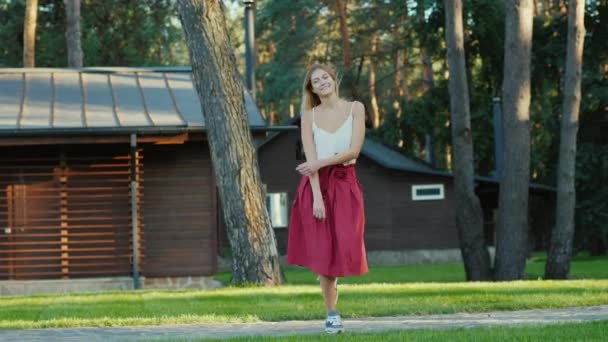 Молодая женщина весело танцует на заднем дворе дома — стоковое видео