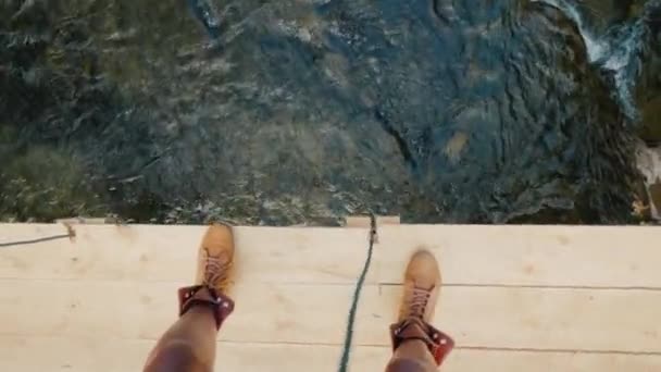 Passeggiata lungo il bordo del traballante ponte di legno attraverso il fiume. Superare fobie e paura concetto — Video Stock