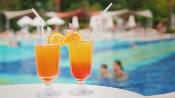 Two exotic cocktails on the background of the pool at the tourist resort — Stock Video