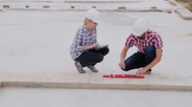Beyaz kask inşaatçılar işin kalitesini kontrol edin. İnşaat teknik kontrol