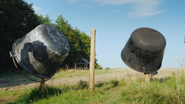 Twee ijzeren tanks voor het maken van kaas worden gedroogd op het hek. Een kleine kaasfabriek in de bergen — Stockvideo