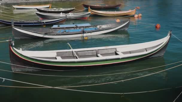 Varios pequeños barcos de madera amarrados en la orilla de un pueblo de pescadores — Vídeo de stock