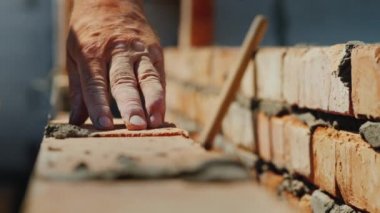 Kendi elleriyle, üst düzey bir adam tarafından tuğla duvar Yeni daireli ev inşaatı yakın çekim