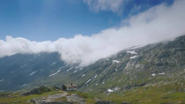 Поездка рядом с живописным горным ландшафтом Норвегии, проезд мимо одинокого деревянного дома. Вид из окна автомобиля — стоковое видео