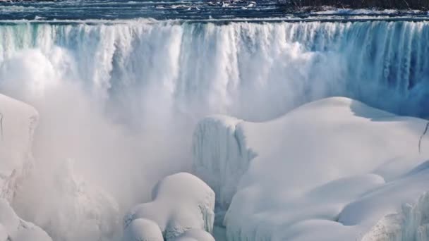 Invierno en las Cataratas del Niágara. El flujo de agua cae sobre bloques de hielo y nieve — Vídeos de Stock