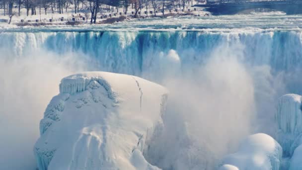 Amerikaanse zijde van Niagara Falls in de winter. Water valt op blokken van ijs en sneeuw — Stockvideo