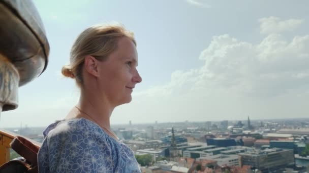 The woman admires the view from a height to Copenhagen. It stands on top of the Church of the Savior, where she climbed the famous spiral staircase — Stock Video