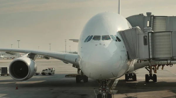 Los pasajeros abordan un enorme avión en el centro. Siluetas visibles de personas que entran en el avión —  Fotos de Stock