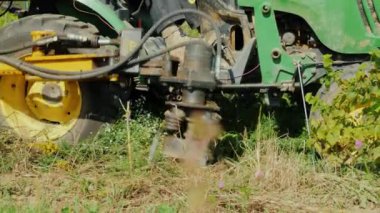 Bir tarım makine otları uproots. Büyüyen böcek ilacı içermeyen ürünler, organik tarım