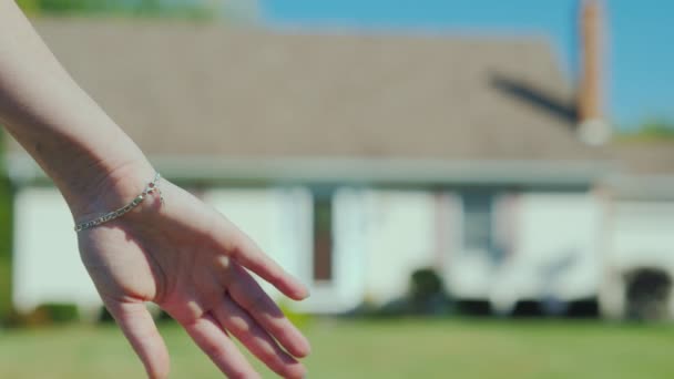 Ein junges Paar hält Händchen vor dem Hintergrund ihrer neuen Heimat. Immobilienkauf-Konzept, ein Traum wird wahr — Stockvideo