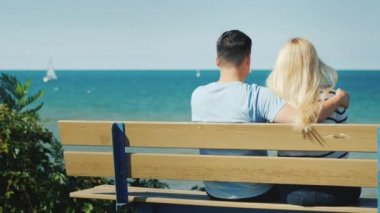Ontario Gölü 'ne bakan bankta dinlenen çok ırklı genç bir çift.