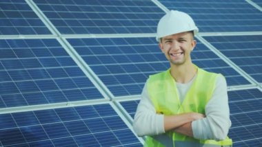 Tulum ve kask güneş panelleri arka plan üzerinde bir işçi portresi. Gülümsüyor, kameraya görünüyor