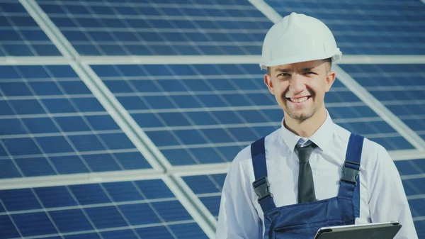 Retrato de un joven ingeniero exitoso en el fondo de una central solar — Foto de Stock