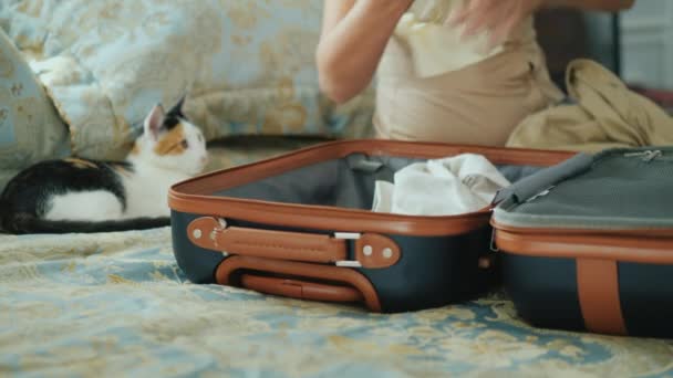 Recoger cosas en el camino. Las manos de mujer ponen la ropa en una pequeña bolsa de viaje — Vídeos de Stock