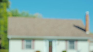 Bir erkek ve bir kadın rüya evlerinin arka plan karşı elele tutuşun. Sadece ellerini çerçevede görülebilir.