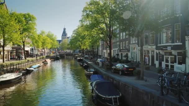 Amesterdam, Nederland, mei 2018: Een van de pittoreske grachten van Amsterdam, de lente zon prachtig verlicht het. — Stockvideo