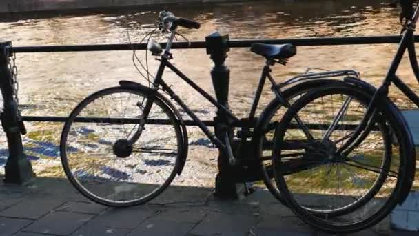 Cykelställ på räcket av kanalen i Amsterdam. Den mest populära typen av transporter i staden — Stockvideo