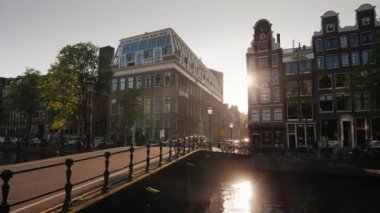 Güzel bir gün batımı Amsterdam'da güneş evler ile parlar ve kanal suya yansıyan