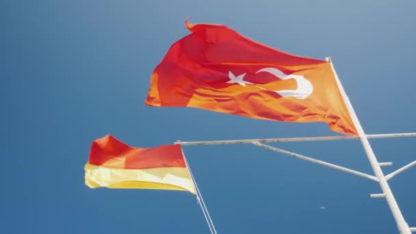 Vermelho com crescente bandeira da Turquia e bandeira de serviço de resgate contra o céu azul. Época de praia na Turquia — Vídeo de Stock