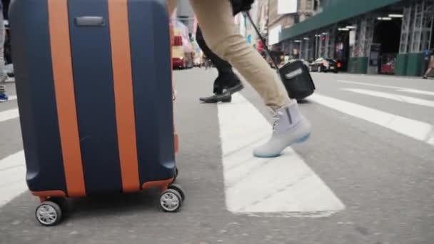 Una mujer con una bolsa de viaje está en un pasaje peatonal en Manhattan. Viajes a Nueva York. Solo las piernas son visibles en el marco . — Vídeos de Stock
