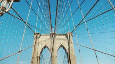 Brooklyn Köprüsü üzerinde yürümek. Dikmesi ve halatlar köprü mavi gökyüzü karşı. POV video