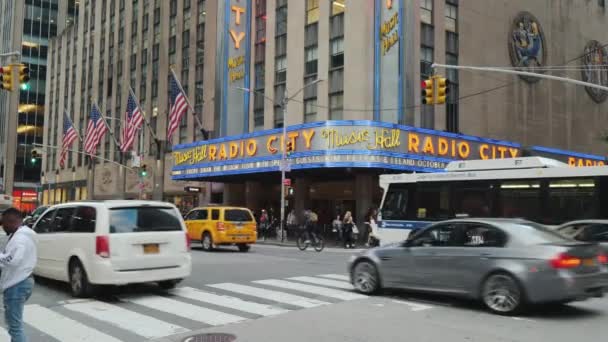 Нью-Йорк, США, вересень 2018: Radio City Music Hall зовнішній вигляд. На передньому плані дорогу з інтенсивним рухом і пішоходів — стокове відео
