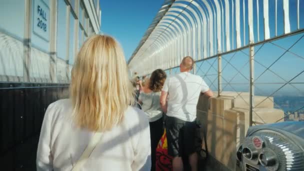 New York, Usa, oktober 2018: A kvinnan promenader bland en skara av turister på observationsdäck i Empire State Building. — Stockvideo