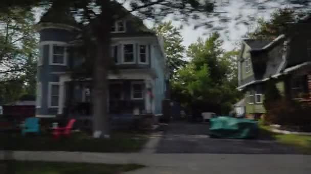 Vista desde la ventana del coche en una calle típica de un pequeño pueblo americano. Casas limpias y césped — Vídeo de stock