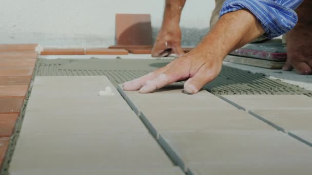 Master posa piastrelle di ceramica sul pavimento . — Video Stock