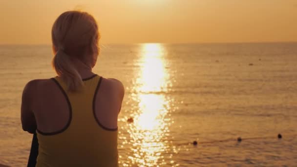 Fitness vrouw bewonderen van de zonsopgang boven de zee — Stockvideo