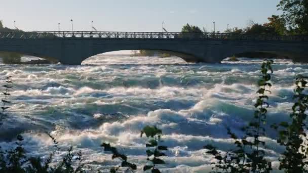 Puente sobre el río Niágara hasta la cascada. Río vibrante que fluye por debajo. Un lugar popular entre los turistas — Vídeos de Stock