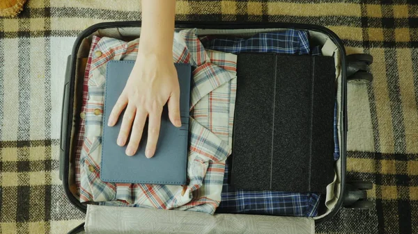 Жінка кладе блокнот у подорожню валізу — стокове фото