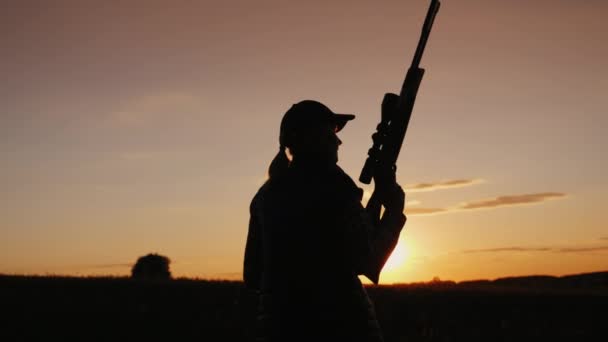 Vue de l'arrière : Une femme armée traverse le champ. Le début de la saison de chasse . — Video