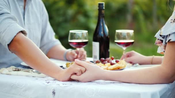 手牵手的年轻夫妇, 浪漫的葡萄酒晚餐 — 图库视频影像