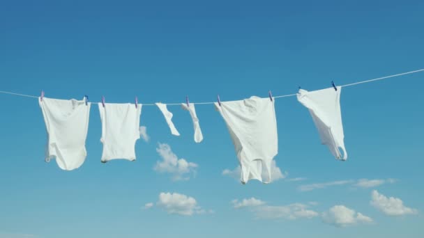 Bílé prádlo schne na laně proti modré obloze — Stock video