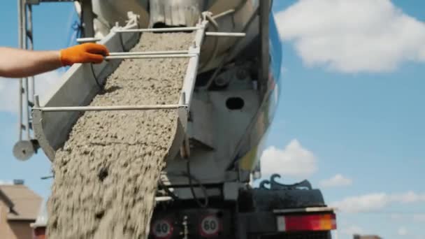 Pracy na wylewania fundamentów, pracownik kieruje rynnie, z którego płynie betonu — Wideo stockowe