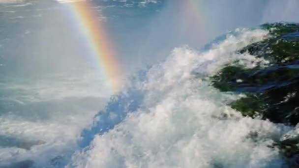 Niagara Falls. Strömmar av vatten rusa ner skumbildning. Stor regnbåge över vattenspray — Stockvideo