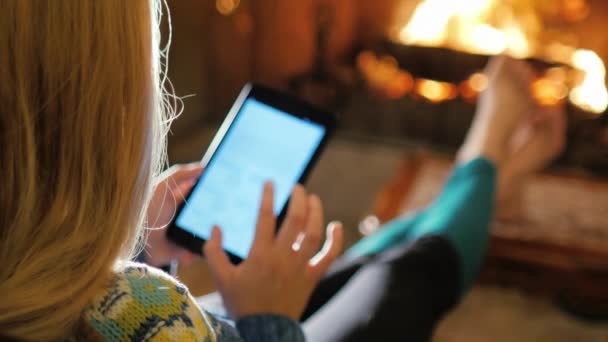 Femme apprécie la tablette près de la cheminée. Vue au-dessus de l'épaule — Video