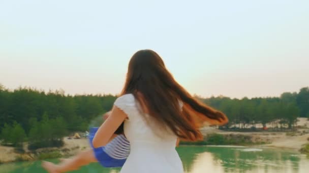Mutter spielt mit ihrer Tochter, umarmt sie und verwandelt sie in einen Sonnenuntergang — Stockvideo