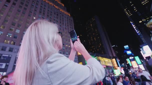 New York, VS, oktober 2018: Vrouw toeristische neemt foto's op Times Square in New York. Toerisme en reizen in de Verenigde Staten. Achteraanzicht — Stockvideo