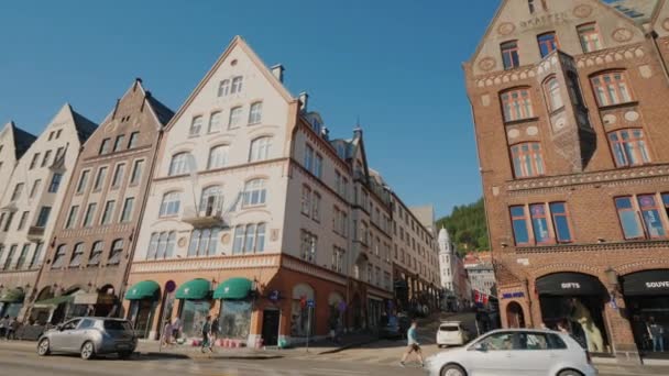 Bergen, Noorwegen, juli 2018: De drukke oude straat van Bergen, intens verkeer en mensen. In de heuvels, pittoreske huizen — Stockvideo