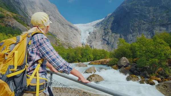 Joven mujer activa admirando la hermosa naturaleza de Noruega - mirando hacia el glaciar Briksdal — Foto de Stock