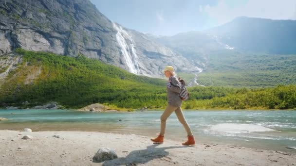 Un viajero camina entre la majestuosa naturaleza: montañas y cascadas. Lugares pintorescos en Noruega — Vídeo de stock