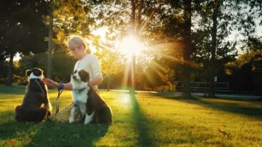 İki köpek ile pets parkta oynarken mutlu bir sahibi portresi, güneş güzel onları aydınlatır