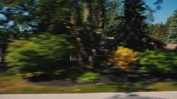 Vue de la fenêtre de la voiture, balades le long des maisons typiques dans une petite ville américaine — Video